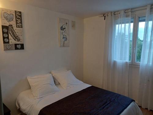 un lit dans une chambre avec une fenêtre dans l'établissement Appartement cosy à 10 min de Paris, à Aubervilliers