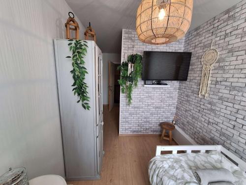 a living room with a tv and a brick wall at "Chez Ba'Nus" in Blankenberge