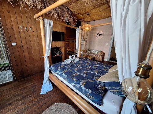 a bedroom with a bed with a blue comforter at "Chez Ba'Nus" in Blankenberge