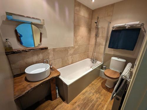 a bathroom with a tub and a sink and a toilet at Bracken in Converted Barn in Dundon