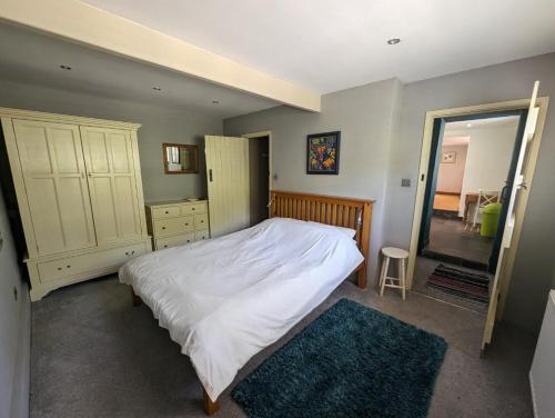 a bedroom with a large white bed and a mirror at Bracken in Converted Barn in Dundon