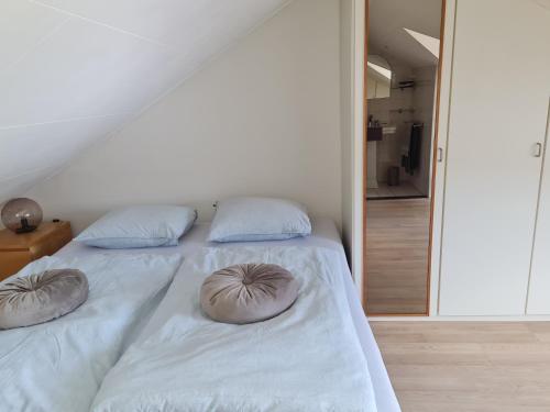 sypialnia z łóżkiem z poduszkami w obiekcie Romantisch Gastenverblijf w mieście Lunteren