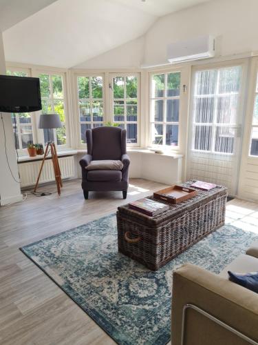 a living room with a chair and a coffee table at Romantisch Gastenverblijf t'Klomperhuys in Lunteren