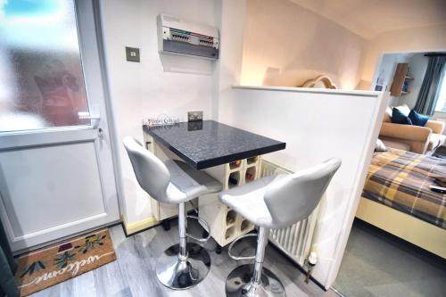a small room with a table and two chairs at Mermaid Cottages in Frinton-on-Sea
