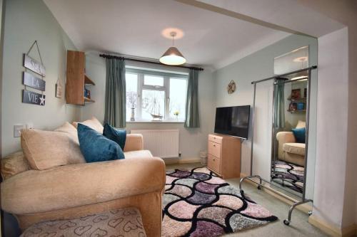 a living room with a couch and a mirror at Mermaid Cottages in Frinton-on-Sea