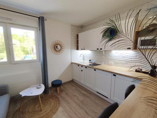 une cuisine avec des armoires blanches, une table et une fenêtre dans l'établissement Home Suite Metz & Place de parking privée, à Metz