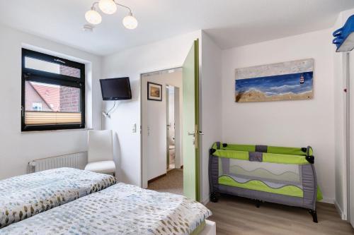 a bedroom with a bed and a tv on the wall at Fewo Strandmuschel in Dangast