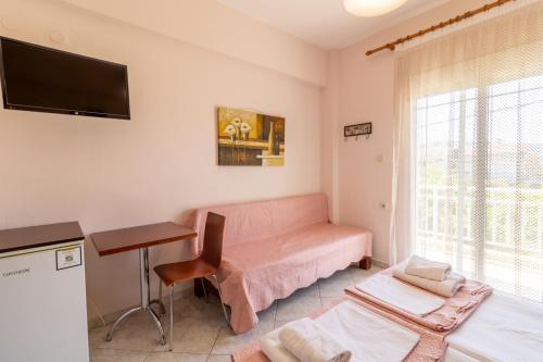 a living room with a pink couch and a desk at Iliadis House in Sarti