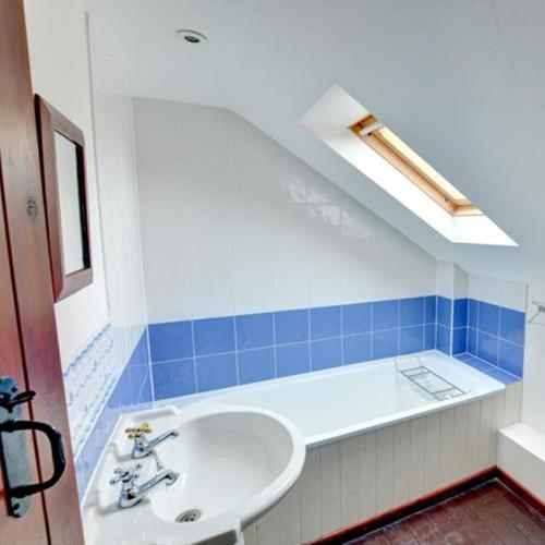 a bathroom with a sink and a bath tub at Llynhillyn Cottage in Presteigne