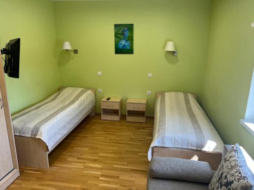 two beds in a room with green walls at Alutaguse Tervisespordikeskuse Päikesemaja in Vasavere