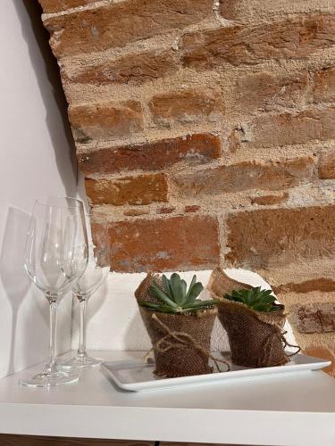 a plate with two wine glasses and a plant on a table at Ca' D'Rosina in Narzole