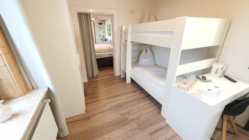 a small room with a bunk bed and a desk at Hotel Schneiderhof in Braunlage