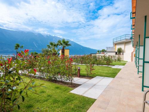 a garden with flowers and mountains in the background at Hotel Cristina in Limone sul Garda