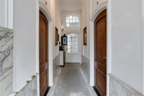 a hallway with two wooden doors and white walls at The Sixteen in Amsterdam