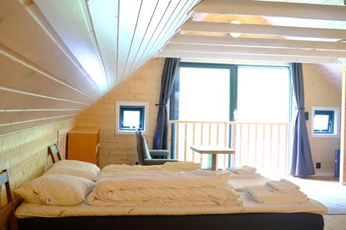 a bedroom with two beds in a room at Minkfarmen, Spacious seaside cabin with scenic view in Ramberg