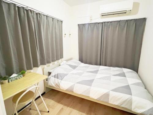 una piccola camera da letto con un letto e una scrivania di 池袋電車2分3Room 6人可 a Tokyo