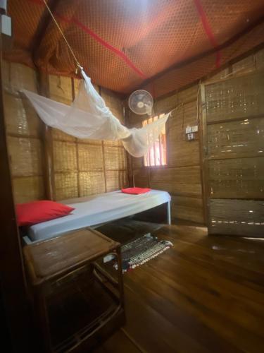 a bed in a room with a mosquito net at CocoHuts in Koh Rong Sanloem