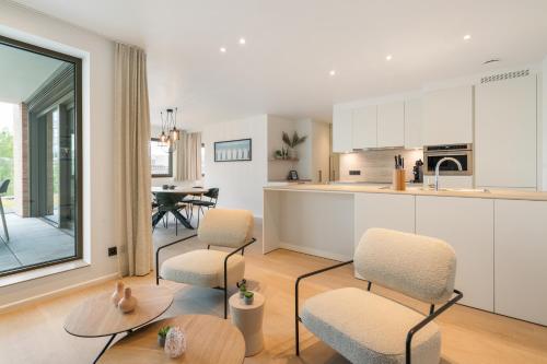 a kitchen and living room with chairs and a table at Paradisio II in Oostduinkerke
