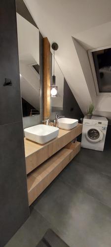 a bathroom with two sinks and a washing machine at Apartamenty Trzy Kopce SKI & BIKE & SAUNA in Ustroń