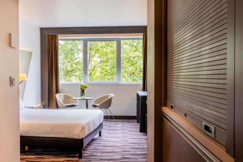 une chambre d'hôtel avec un lit et une fenêtre dans l'établissement Nemea Appart Hotel Concorde Toulouse Gare Matabiau, à Toulouse