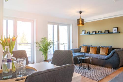 a living room with a couch and a table at FAIRflats: Küche, Balkon, Arbeitsplatz, Aufzug in Hüfingen