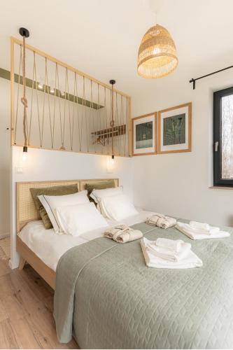a bedroom with a bed with two towels on it at BLACKWOOD Vendégház in Kesztölc