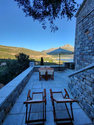 a patio with two chairs and a table and an umbrella at Casa Nostra Maisonette in Oítilon