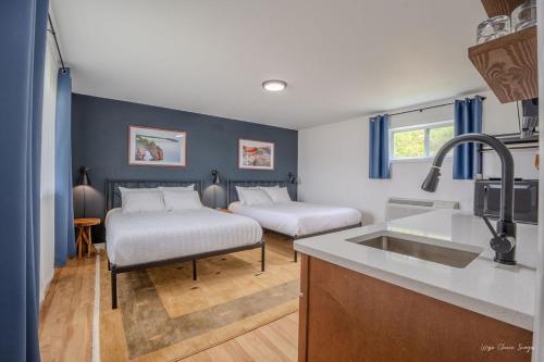 a kitchen with two beds and a sink in a room at The Inn at Shady Pines in Gros Cap