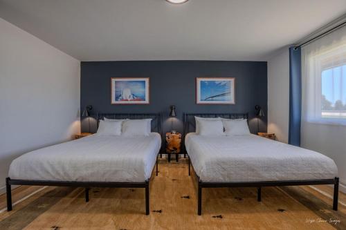 two beds in a room with blue walls at The Inn at Shady Pines in Gros Cap