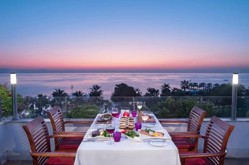 a table with food and wine on a balcony with a view at Nirvana Mediterranean Excellence - Ultra All Inclusive in Beldibi