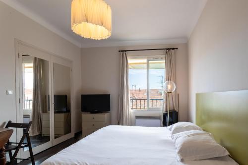 une chambre avec un grand lit blanc et une fenêtre dans l'établissement URBAN AP4346 By Riviera Holiday Homes, à Nice