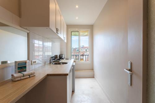 une cuisine blanche avec un évier et une fenêtre dans l'établissement URBAN AP4346 By Riviera Holiday Homes, à Nice