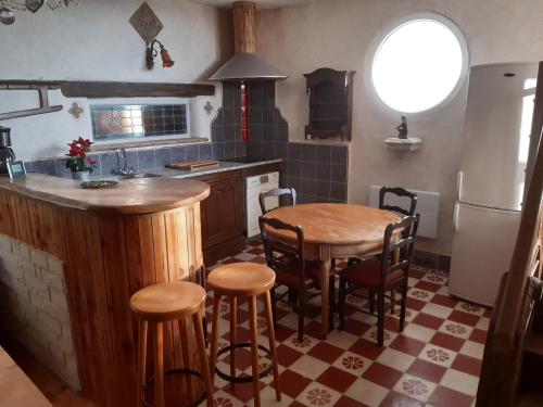 une cuisine avec une table et des tabourets dans l'établissement La chanvriere, à Manheulles