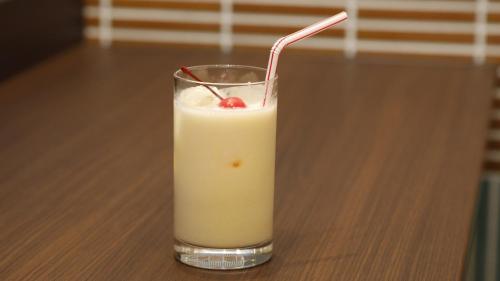 un vaso de leche con una cereza en una mesa en Dormy Inn Premium Osaka Kitahama en Osaka