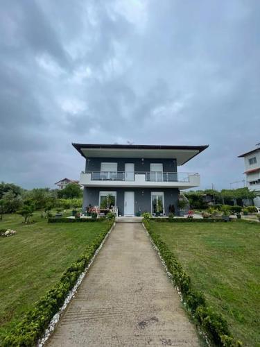 a large house with a pathway in front of it at Dragoti in Leptokaria