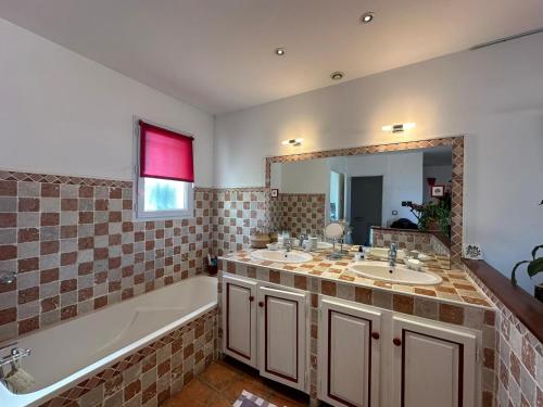 La salle de bains est pourvue de 2 lavabos, d'une baignoire et d'une baignoire. dans l'établissement Maison provençale avec vue sur mer, à Marseille