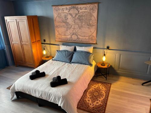 une chambre avec un lit avec deux boîtes noires dessus dans l'établissement Appartement Chic & Baroque 5 min centre ville et Bord de Vienne, à Limoges