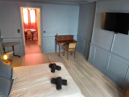 una camera da letto con un letto e pantofole nere di Appartement Chic & Baroque 5 min centre ville et Bord de Vienne a Limoges