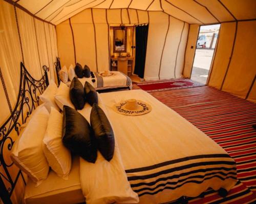 a bedroom with two beds in a tent at RiadSuerteloca Merzouga in Merzouga