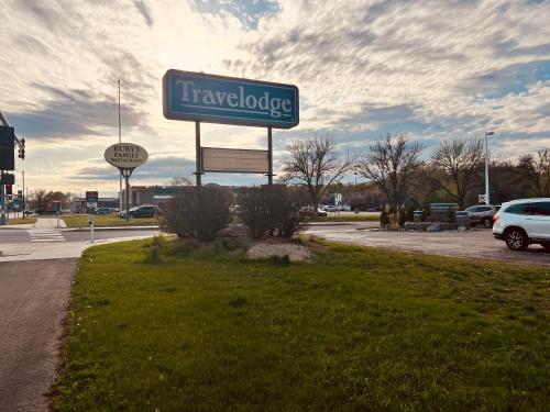 a sign for a car dealership in a parking lot at Travelodge by Wyndham Valleyfair Shakopee in Shakopee