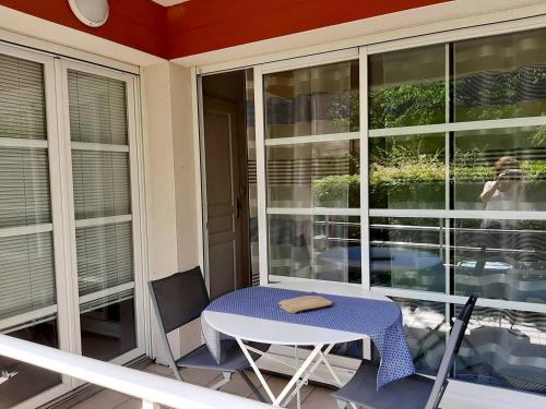 une table et des chaises sur un balcon avec une fenêtre dans l'établissement Résidence AMARINE- Appartement avec terrasse couverte pour 3 personnes, à Hossegor