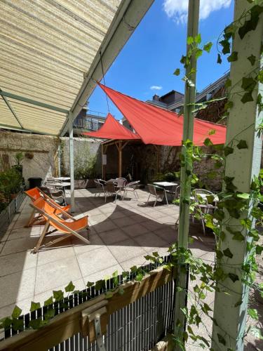 a patio with a red roof and a table and chairs at Hôtel Continental in Évian-les-Bains