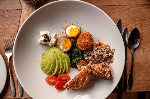 a plate of food with eggs and vegetables on a table at Kapama Southern Camp in Kapama Private Game Reserve