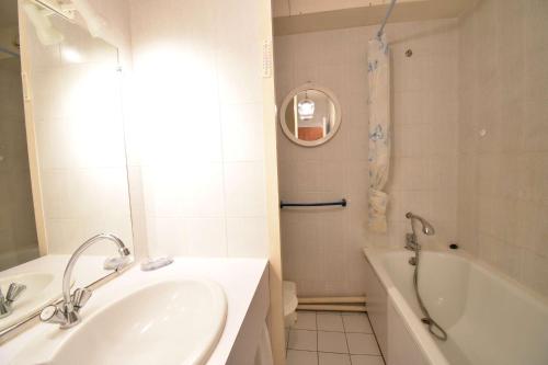 une salle de bain avec une baignoire et un lavabo et une baignoire dans l'établissement Résidence Les Terrasses de Notre Dame, bel appartement avec vue sur l'entrée du port, à Capbreton