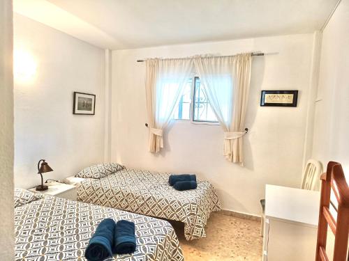 A bed or beds in a room at APARTAMENTO AGUAMARINA Nsf54 -NERJA