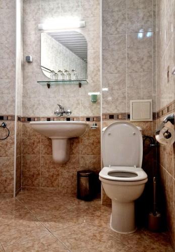 a bathroom with a toilet and a sink at Къща за гости Карел in Nesebar