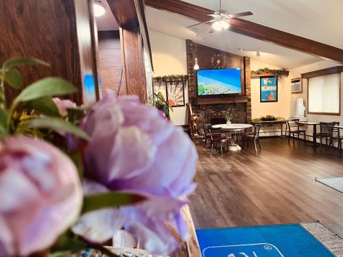 a living room with a tv and a table with chairs at Travelodge by Wyndham Valleyfair Shakopee in Shakopee