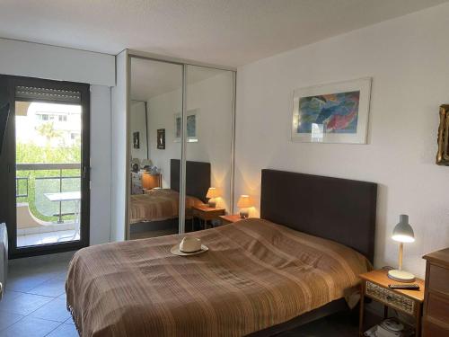 une chambre avec un lit et un grand miroir dans l'établissement Appartement 2 pièces avec terrasse près de la plage - FR-1-226A-344, à Fréjus