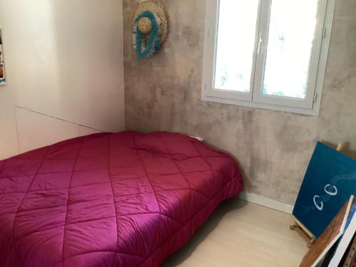 - un lit violet dans une chambre avec fenêtre dans l'établissement Sous le garlaban, à Aubagne
