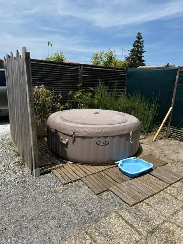 un jacuzzi et un frisbee bleu au sol dans l'établissement Chalet avec SPA à Biscarrosse, à Biscarrosse